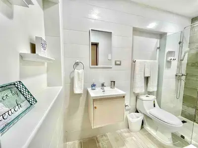 a white bathroom with a toilet and a sink at Las Terrenas beachfront 2 bedrooms condo with pool in Las Terrenas