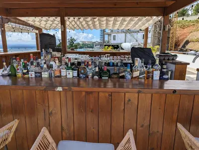 a bar with a lot of bottles of alcohol at Hacienda Samana Bay Hotel in Santa Bárbara de Samaná
