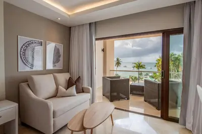 a living room with a couch and a view of the ocean at Hacienda Samana Bay Hotel in Santa Bárbara de Samaná