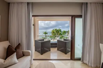 a living room with a couch and a sliding glass door at Hacienda Samana Bay Hotel in Santa Bárbara de Samaná