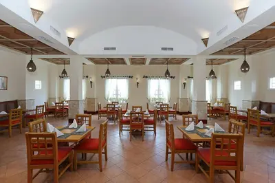 a dining room with tables and chairs and windows at Four Points by Sheraton Santo Domingo in Santo Domingo