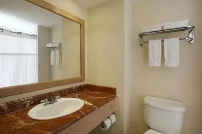 a bathroom with a sink and a toilet and a mirror at Four Points by Sheraton Santo Domingo in Santo Domingo
