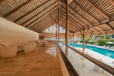 a resort lobby with a swimming pool and a large ceiling at Newly Added 1BR El Portillo Luxury in Portillo