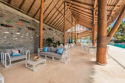 a resort lobby with chairs and a swimming pool at Newly Added 1BR El Portillo Luxury in Portillo