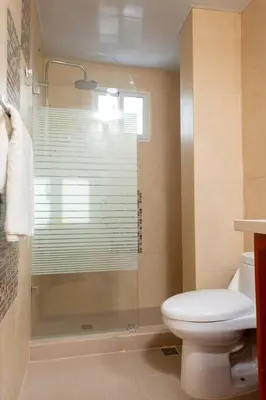 a bathroom with a toilet and a glass shower at Maravilloso Apto en Santo Domingo in Santo Domingo