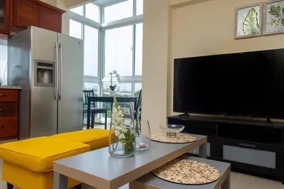 a living room with a yellow couch and a tv at Maravilloso Apto en Santo Domingo in Santo Domingo