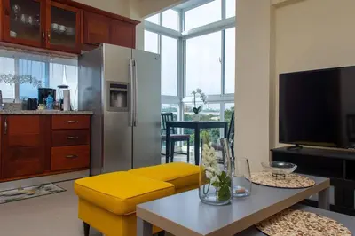 a living room with a yellow couch and a table at Maravilloso Apto en Santo Domingo in Santo Domingo