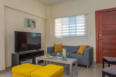 a living room with a blue couch and a tv at Maravilloso Apto en Santo Domingo in Santo Domingo