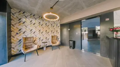 a lobby with two chairs and a wall with a fish mural at Breakfast Included Fully Serviced Apartment at Regatta Living II - 204 in Santo Domingo