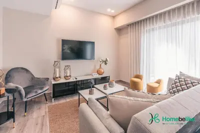 a living room with a couch and a tv at Breakfast Included Fully Serviced Apartment at Regatta Living II - 204 in Santo Domingo