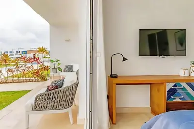 a bedroom with a desk and a tv and a chair at Cana Rock 108 Acceso Directo Piscina Punta Cana in Punta Cana