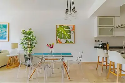 a dining room with a glass table and chairs at Cana Rock 108 Acceso Directo Piscina Punta Cana in Punta Cana