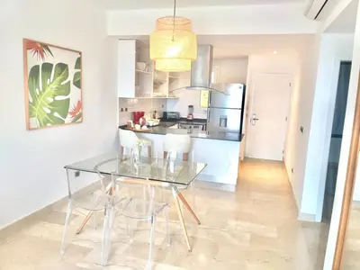a dining room with a glass table and chairs at Cana Rock 351 Impresionante Vista A La Piscina in Punta Cana
