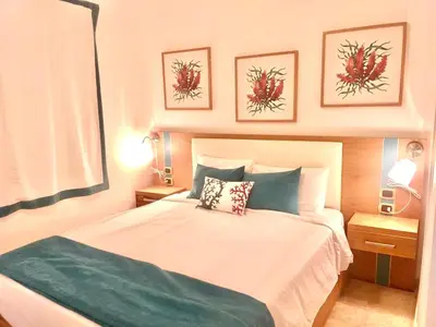 a bedroom with a bed and two pictures on the wall at Cana Rock 351 Impresionante Vista A La Piscina in Punta Cana