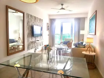 a living room with a glass table in a room at Cana Rock 351 Impresionante Vista A La Piscina in Punta Cana