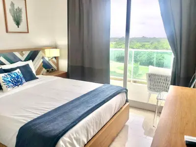 a bedroom with a bed and a large window at Cana Rock 351 Impresionante Vista A La Piscina in Punta Cana