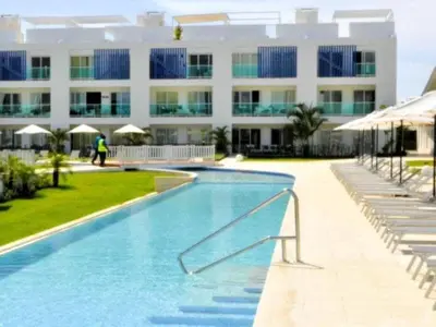 a swimming pool in front of a large building at Apartamento 120 Jardin Privado Cana Rock in Punta Cana