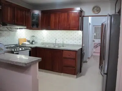 a kitchen with wooden cabinets and a refrigerator at LEAN LUXURY Santo Domingo in Santo Domingo