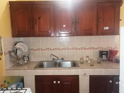 a kitchen with wooden cabinets and a sink at Las colinas de Samaná in Santa Bárbara de Samaná