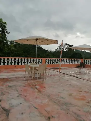 a table and chairs with an umbrella on a patio at Las colinas de Samaná in Santa Bárbara de Samaná
