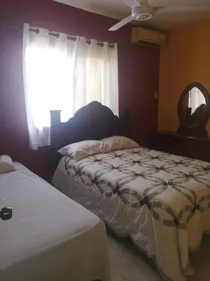 a bedroom with two beds and a window at Las colinas de Samaná in Santa Bárbara de Samaná