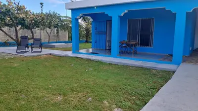 a blue house with chairs and a yard at Casa A&A in Las Galeras