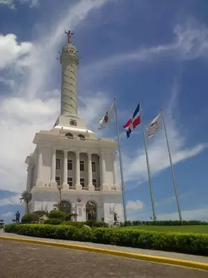 a white lighthouse with flags in front of it at Acogedor-Hermoso apart completo equipado de 2 hab. in Santiago de los Caballeros