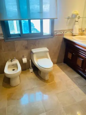 a bathroom with a toilet and a bidet and a sink at Malecón vista mar Habitación Privada Larimar, in Santo Domingo