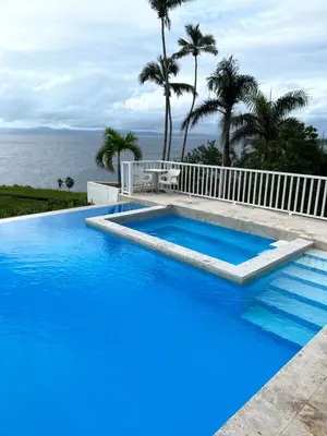 a large blue swimming pool next to the ocean at Vista Mare Samana The Best View!! in Santa Bárbara de Samaná