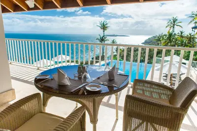 a table and chairs on a balcony with a view of the ocean at Vista Mare Samana The Best View!! in Santa Bárbara de Samaná