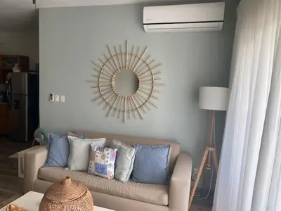 a living room with a couch and a mirror at Cadaques Caribe Bayahibe in Bayahibe
