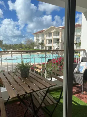a wooden bench on a balcony with a view of the water at Cadaques Caribe Bayahibe in Bayahibe