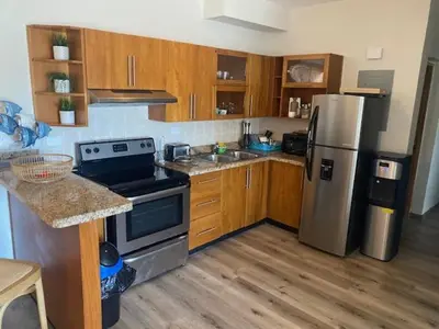 a kitchen with wooden cabinets and stainless steel appliances at Cadaques Caribe Bayahibe in Bayahibe