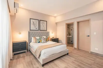 a bedroom with a large bed and a hallway at Apartment at Regatta Living II - 406 fully-equipped in Los Prados