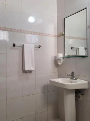 a white bathroom with a sink and a mirror at Drake Bolivar Santo Domingo in Santo Domingo