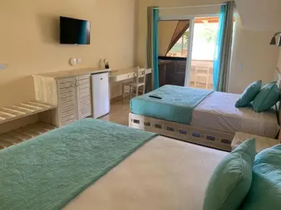 a bedroom with two beds and a desk with a mirror at guest house MY WAY in Las Terrenas