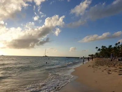 a beach with a group of people and the ocean at PLAYA BLANCA BED AND BREAKFAST in Bayahibe