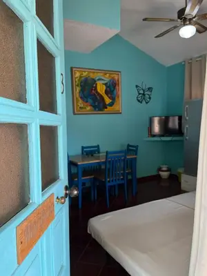 a room with a bed and a table and a ceiling fan at PLAYA BLANCA BED AND BREAKFAST in Bayahibe