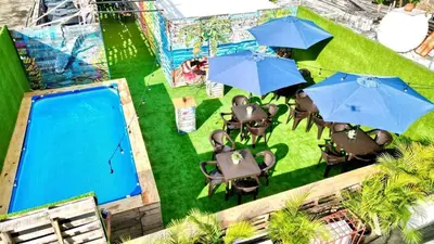 an overhead view of a pool with tables and umbrellas at Hotel Tau Art Residence in Santo Domingo