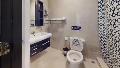 a bathroom with a white toilet and a sink at Hotel Tau Art Residence in Santo Domingo