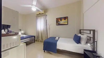 a bedroom with two beds and a blue blanket at Hotel Tau Art Residence in Santo Domingo