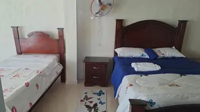 a bedroom with two beds and a nightstand and sidx sidx sidx at Casa taina in Jarabacoa