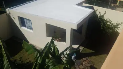 a small white building with a window and some plants at Casa taina in Jarabacoa