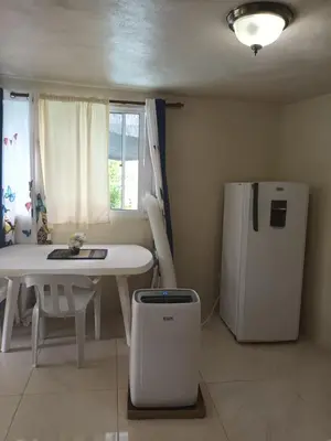 a kitchen with a table and a white refrigerator at Casa taina in Jarabacoa