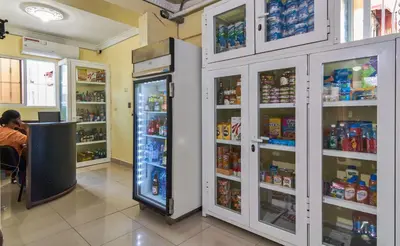 a man sitting at a counter in a store with a refrigerator at Cozy One Bedroom Apartment in Santo Domingo Este in La Viva