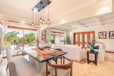 a dining room and living room with a table and chairs at Villa with 3 bedrooms private pool and ocean view in Santa Bárbara de Samaná