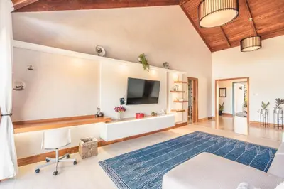 a living room with a tv and a blue rug at Villa with 3 bedrooms private pool and ocean view in Santa Bárbara de Samaná
