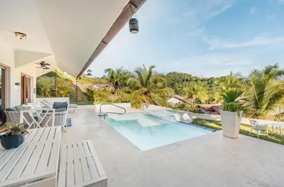 an outdoor patio with a swimming pool and a resort at Villa with 3 bedrooms private pool and ocean view in Santa Bárbara de Samaná