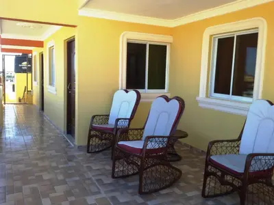 a group of chairs sitting on a porch at Cozy Apartment Near Airport Wi-Fi & Parking in La Viva