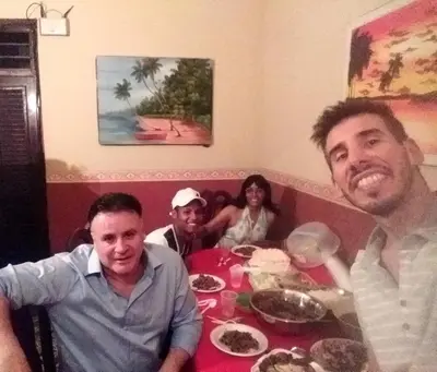 a group of people sitting around a table with food at La casa de Jessica in Santo Domingo